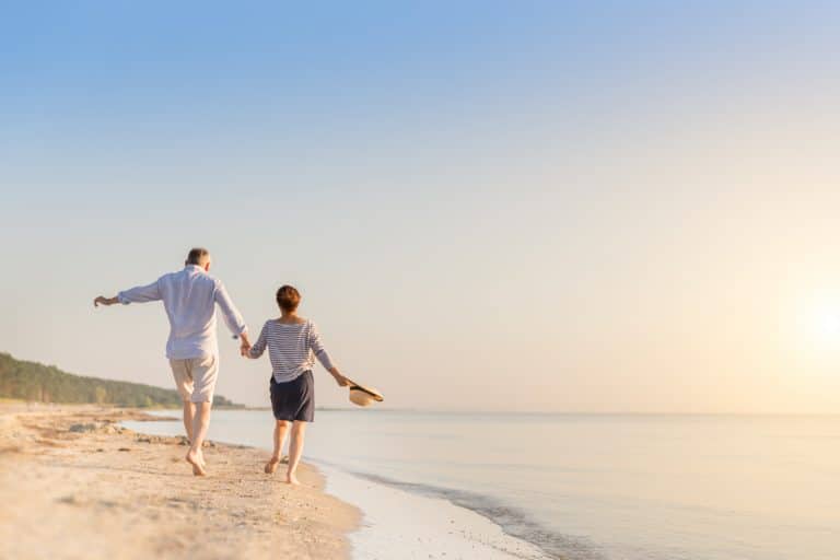 Älteres Paar läuft am Strand: Langlebigkeit ist kein Sprint, sondern ein Marathon. Schritt für Schritt kann gesundes Altern erreicht werden