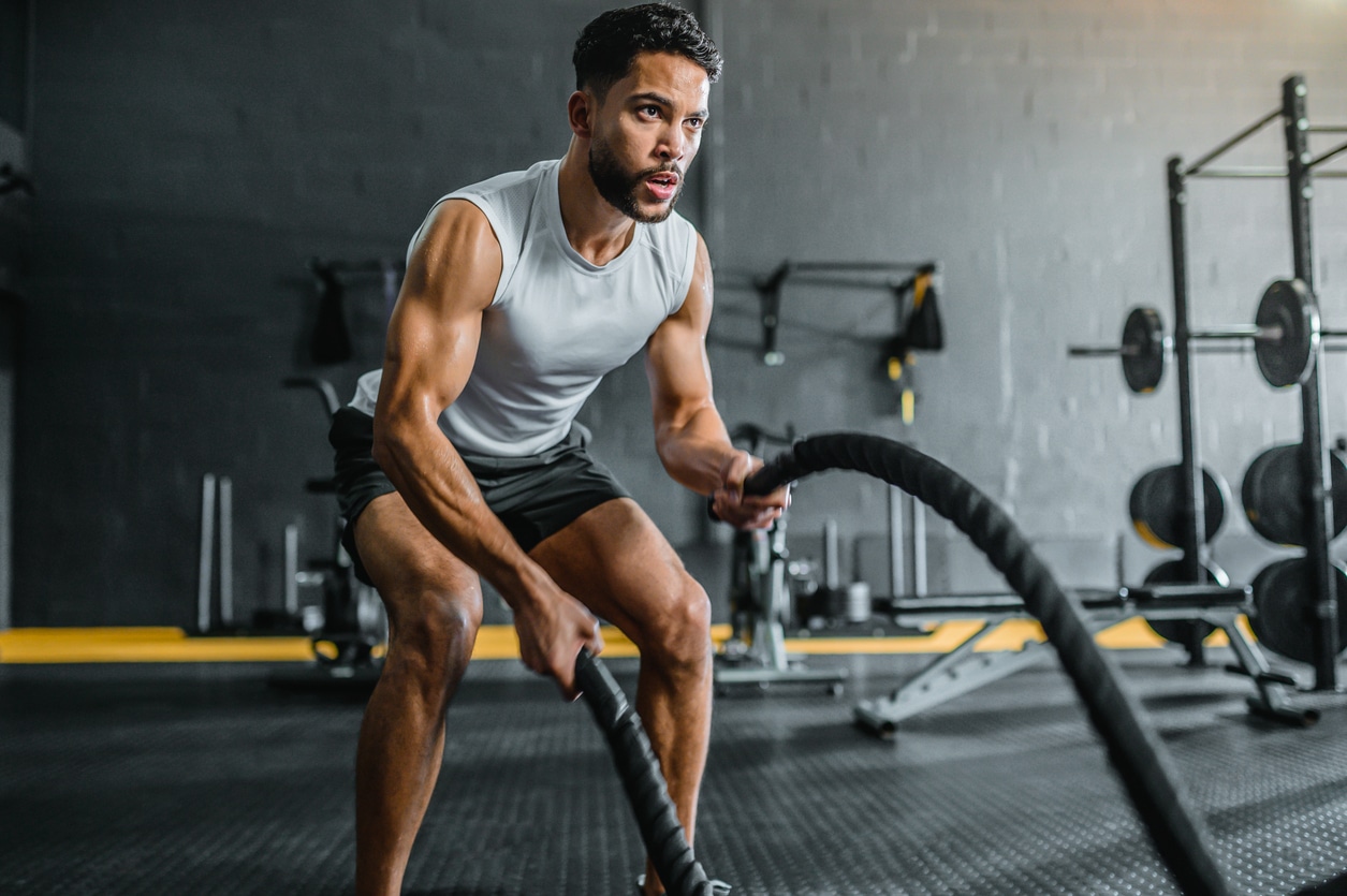 Fitter junger Mann beim Training mit Seilen. Fitness fördert Mitochondrien Gesundheit