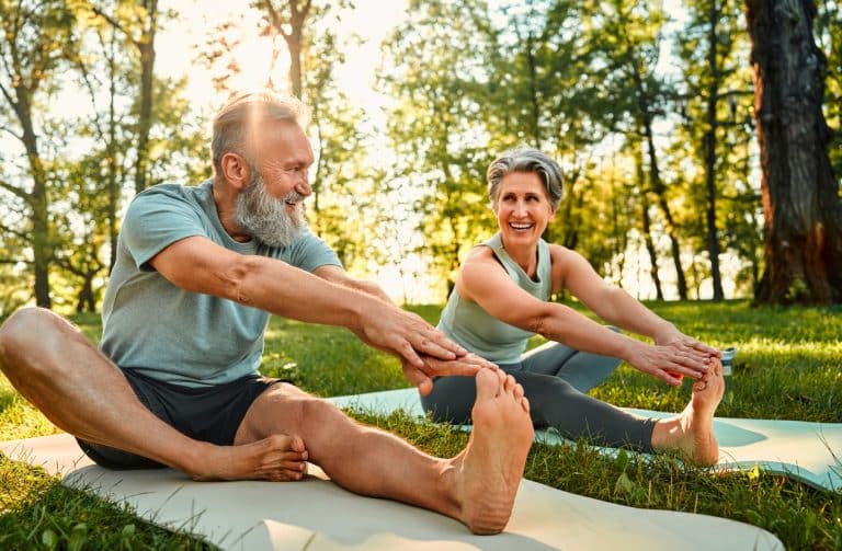 Älteres, vitales Paar beim Yoga. Mitochondriengesundeheit ist eng mit körperlicher Aktivität verbunden