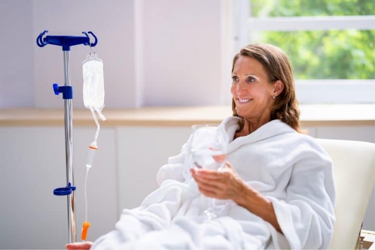 Frau mit Infusion am Arm. Intravenöse NAD+ Infusionen versprechen sofortigen Energie-Boost