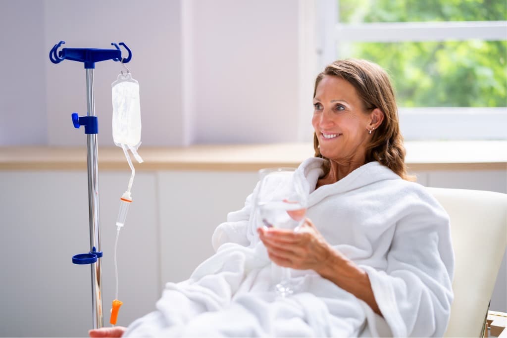 Frau mit Infusion am Arm. Intravenöse NAD+ Infusionen versprechen sofortigen Energie-Boost